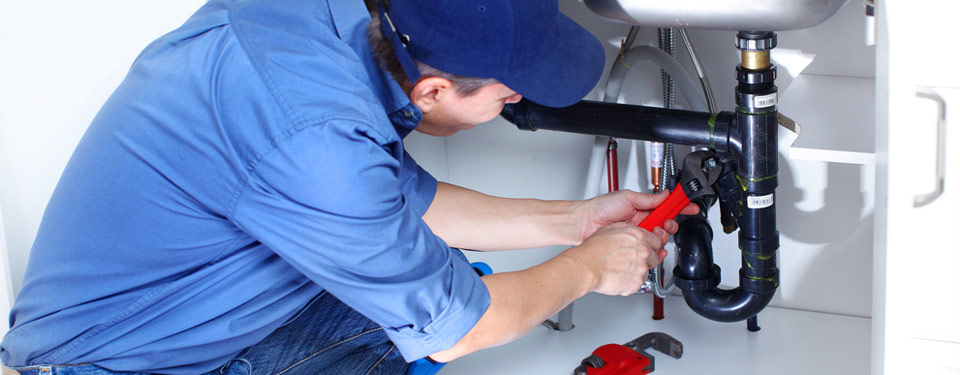 Plumber fixing drainpipe